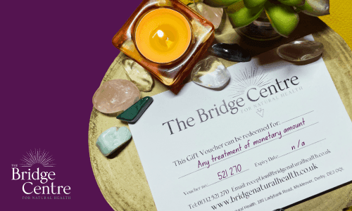 A gift voucher for The Bridge Centre for Natural Health, Derby surrounded by candle and crystals