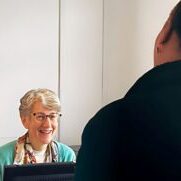A patient talking to the receptionist at The Bridge Centre for Natural Health, Mickleover, Derby